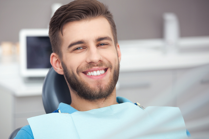 Portrait of happy patient in dental chair.